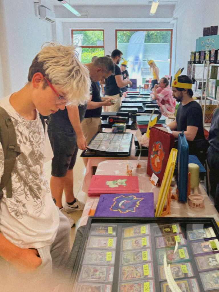 Uczestnicy oglądają klasery z kartami przy stoiskach pierwszej edycji Mini CardShow